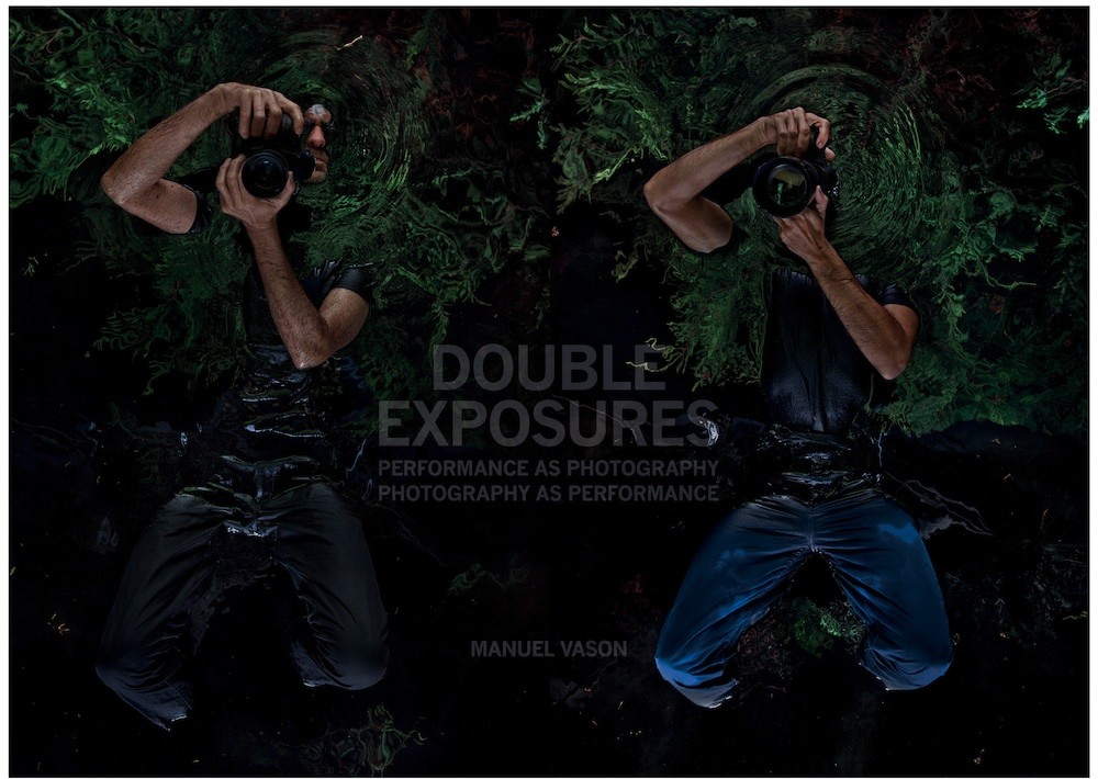 book cover of Manuel Vason 'Double Exposures'. Two figures lie on their backs in dark water, holding cameras over their faces which are pointed up to us, as if taking the viewer's picture. The image is dark, with green reflections in the water