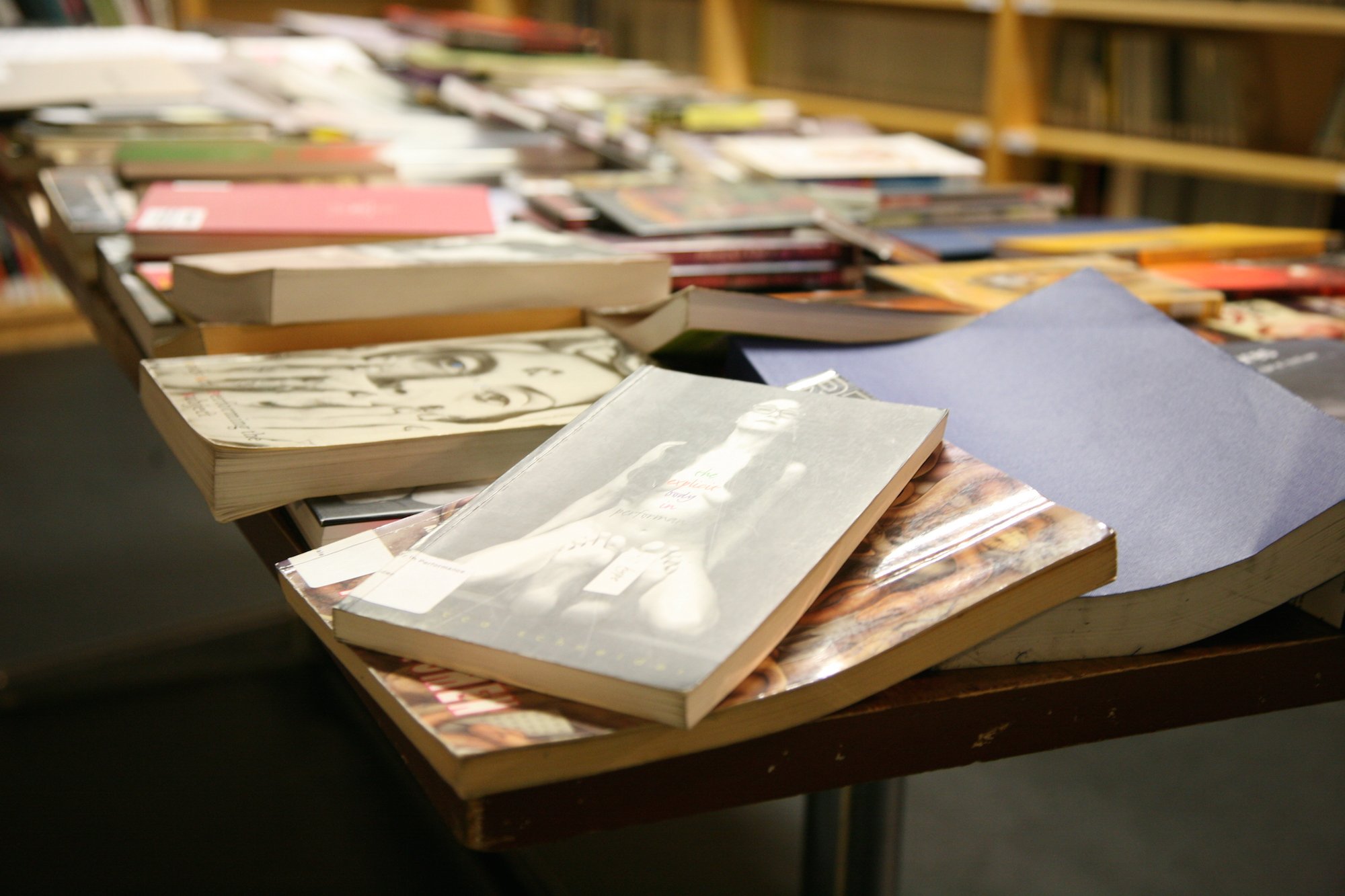 Books are piled on a table.