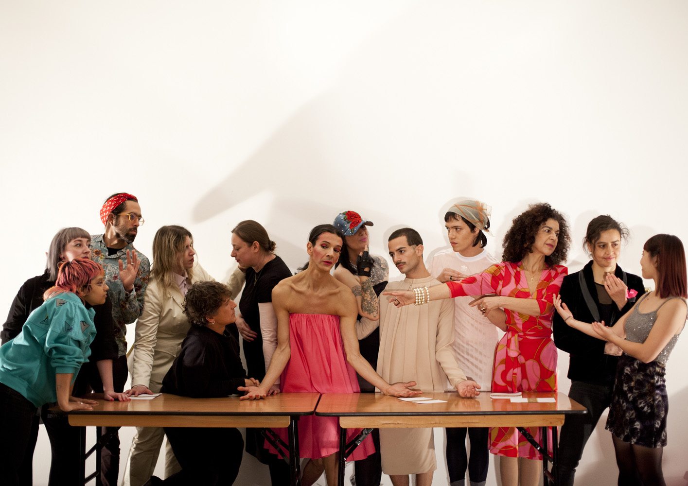 The artist is surrounded by trans and queer people, recreating the image of the last supper but everyone is wearing pink.