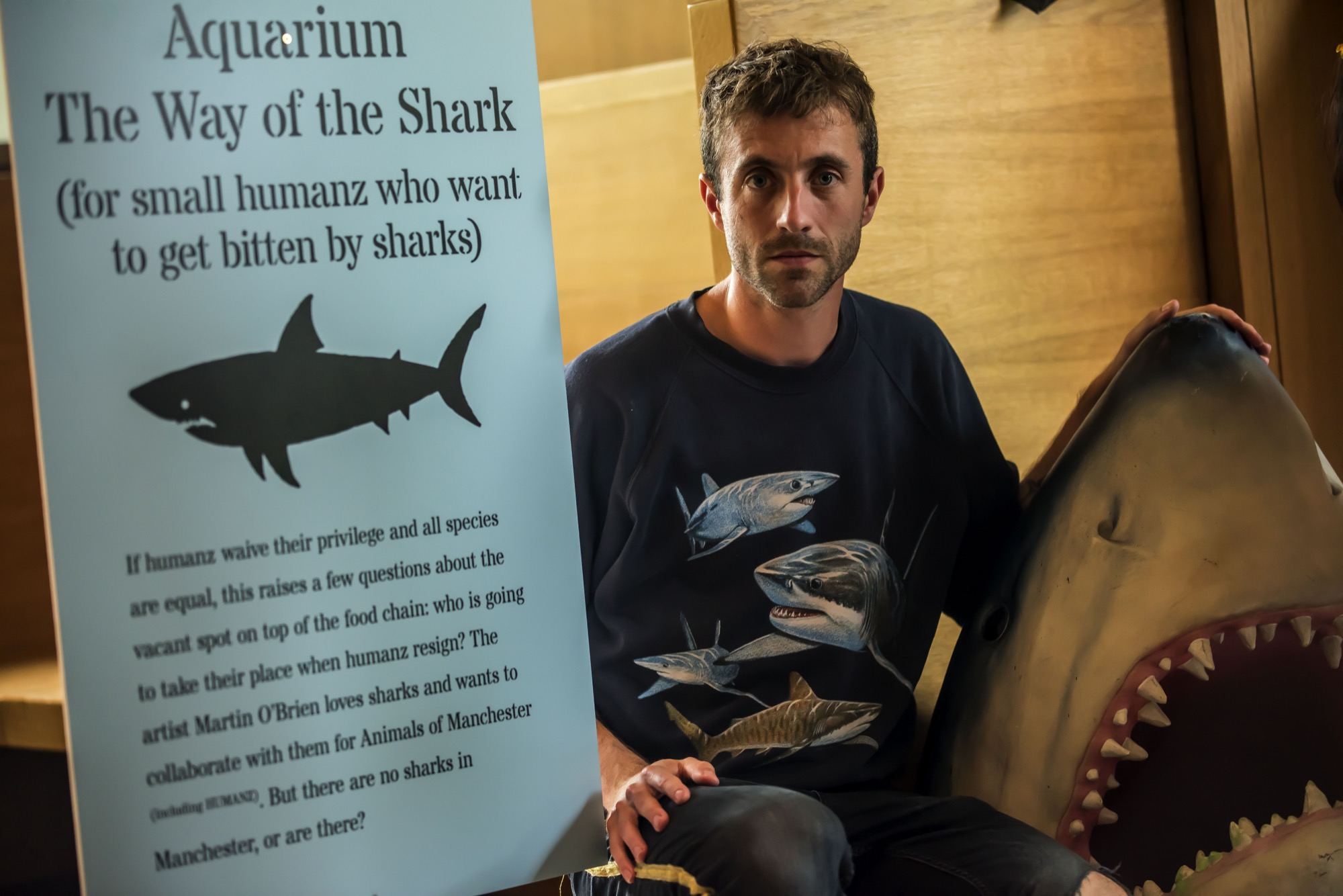 artist martin o brien next to a poster with a shark