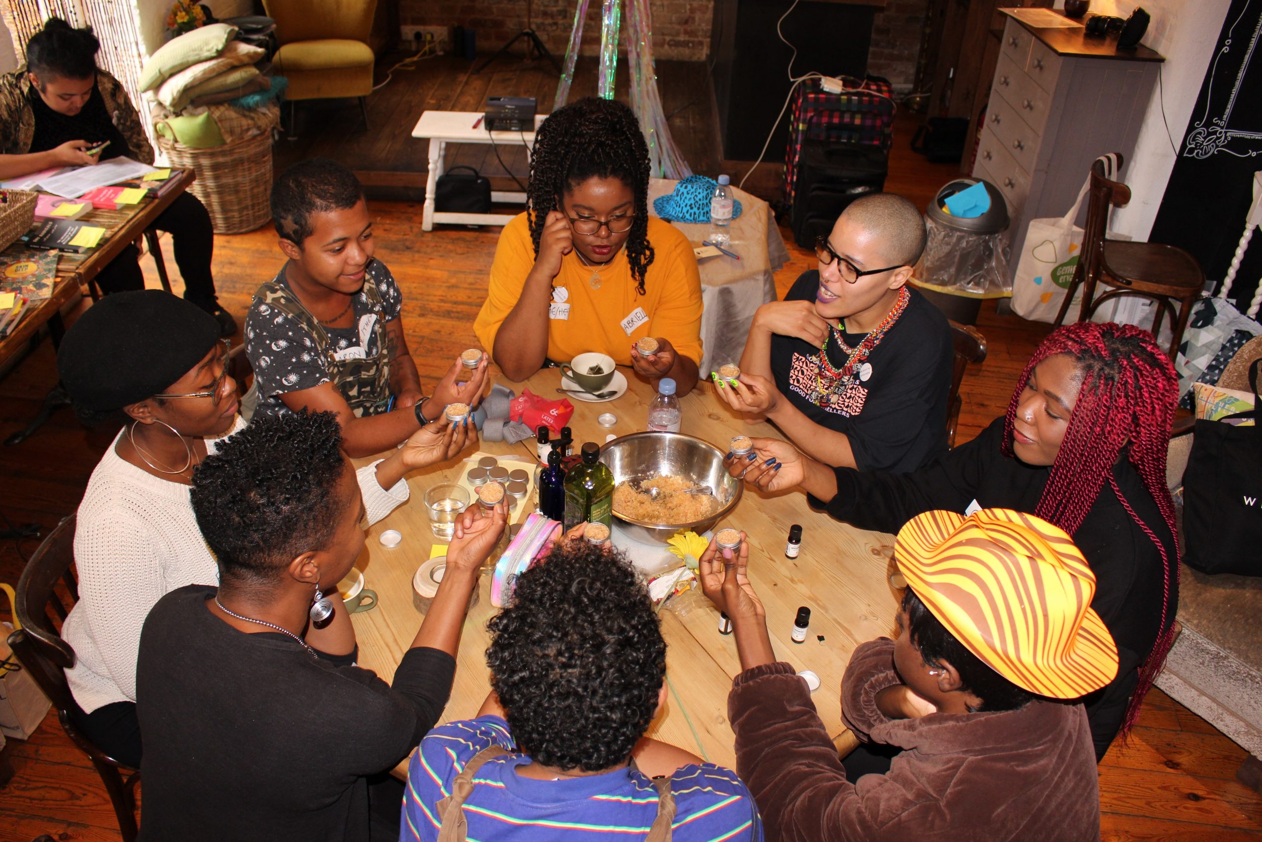 8 people sit around a table smiling at each other, the photo is taken from above