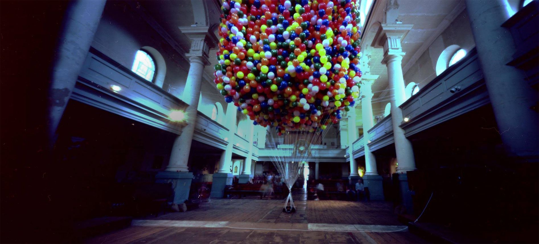 Artist is lifted into the air by hellium balloons